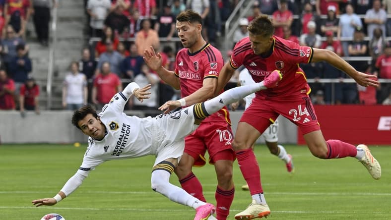 Jun 11, 2023; St. Louis, Missouri, USA; Los Angeles Galaxy midfielder Riqui Puig (6) and St. Louis City midfielder Eduard Lowen (10) and defender Lucas Bartlett (24) collide in the first half at CITYPARK. Mandatory Credit: Scott Rovak-USA TODAY Sports