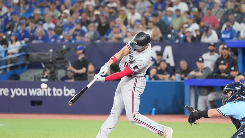 Jun 11, 2023; Toronto, Ontario, CAN; Minnesota Twins left fielder Trevor Larnach (9) hits a two-run single against the Toronto Blue Jays during the first inning at Rogers Centre. Mandatory Credit: Nick Turchiaro-USA TODAY Sports
