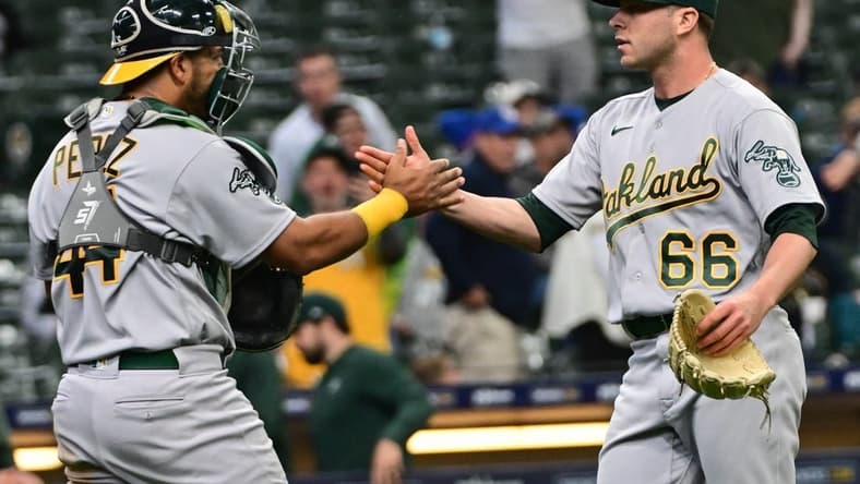 Jun 11, 2023; Milwaukee, Wisconsin, USA; Oakland Athletes pitcher Sam Long (66) celebrates with catcher Carlos P rez (44) after picking up a save against the Milwaukee Brewers at American Family Field. Mandatory Credit: Benny Sieu-USA TODAY Sports