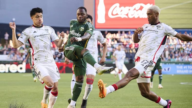 Jun 11, 2023; Portland, Oregon, USA;  Portland Timbers forward Franck Boli (7) takes a shot on goal during the first half against FC Dallas defender Marco Farfan (4) and defender Nkosi Tafari (17) at Providence Park. Mandatory Credit: Troy Wayrynen-USA TODAY Sports