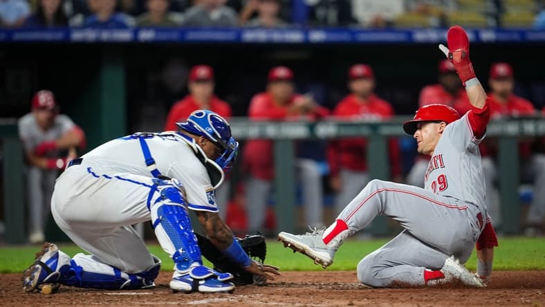 Jun 12, 2023; Kansas City, Missouri, USA; Cincinnati Reds center fielder TJ Friedl (29) slides into home to score the go-ahead run ahead of the tag by Kansas City Royals catcher Salvador Perez (13) during the tenth inning at Kauffman Stadium. Mandatory Credit: Jay Biggerstaff-USA TODAY Sports
