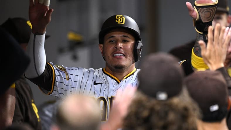 Jun 13, 2023; San Diego, California, USA; San Diego Padres third baseman Manny Machado (right) is congratulated in the dugout after scoring a run against the Cleveland Guardians during the fifth inning at Petco Park. Mandatory Credit: Orlando Ramirez-USA TODAY Sports