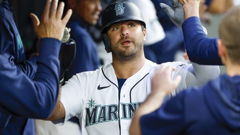 Jun 13, 2023; Seattle, Washington, USA; Seattle Mariners designated hitter Mike Ford (20) high-fives teammates in the dugout after scoring a run against the Miami Marlins during the sixth inning at T-Mobile Park. Mandatory Credit: Joe Nicholson-USA TODAY Sports
