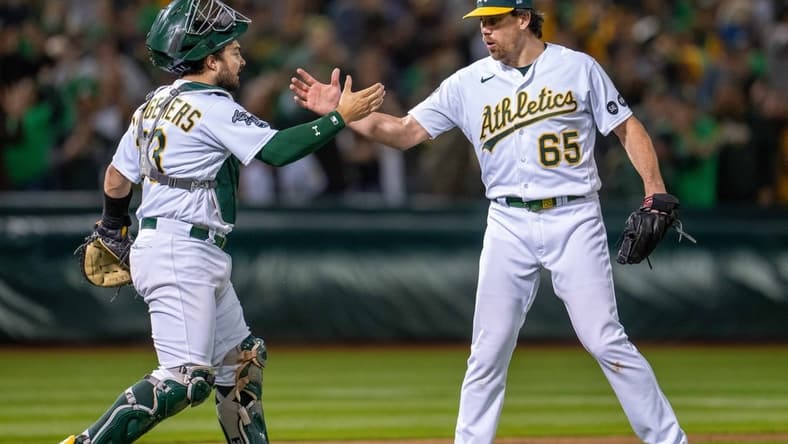 Jun 13, 2023; Oakland, California, USA; Oakland Athletics relief pitcher Trevor May (65) and catcher Shea Langeliers (23) celebrate after the game against the Tampa Bay Rays at Oakland-Alameda County Coliseum. Mandatory Credit: Neville E. Guard-USA TODAY Sports