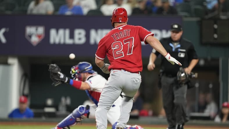 Jun 14, 2023; Arlington, Texas, USA; Los Angeles Angels center fielder Mike Trout (27) runs home to score as Texas Rangers catcher Mitch Garver (18) is unable to catch the throw during the third inning at Globe Life Field. Mandatory Credit: Jim Cowsert-USA TODAY Sports