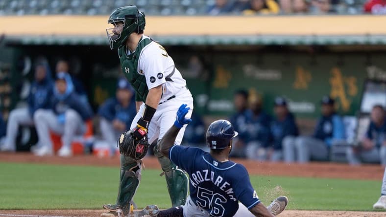 Jun 14, 2023; Oakland, California, USA;  Tampa Bay Rays left fielder Randy Arozarena (56) slides home safe during the second inning against Oakland Athletics catcher Shea Langeliers (23) at Oakland-Alameda County Coliseum. Mandatory Credit: Stan Szeto-USA TODAY Sports