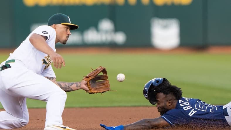 Jun 14, 2023; Oakland, California, USA;  Tampa Bay Rays left fielder Randy Arozarena (56) attempts to beat the ball during the fourth inning against the Oakland Athletics third baseman Jace Peterson (6) at Oakland-Alameda County Coliseum. Mandatory Credit: Stan Szeto-USA TODAY Sports