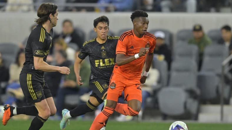Jun 14, 2023; Los Angeles, California, USA; Houston Dynamo forward Nelson Quinones (21) dribbles the ball ahead against Los Angeles FC defender Erik Duenas (18) during the first half at BMO Stadium. Mandatory Credit: Jayne Kamin-Oncea-USA TODAY Sports