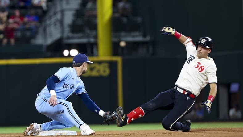 Jun 16, 2023; Arlington, Texas, USA; Toronto Blue Jays second baseman Cavan Biggio (8) tags out Texas Rangers first baseman Nathaniel Lowe (30) at second base during the eighth inning at Globe Life Field. Mandatory Credit: Kevin Jairaj-USA TODAY Sports