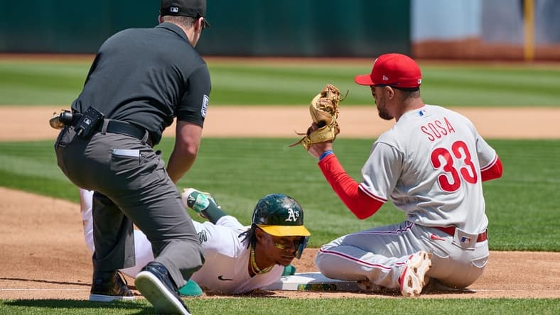 Jun 17, 2023; Oakland, California, USA; Oakland Athletics outfielder Esteury Ruiz (1) steals third base against Philadelphia Phillies infielder Edmundo Sosa (33) during the fourth inning at Oakland-Alameda County Coliseum. Mandatory Credit: Robert Edwards-USA TODAY Sports