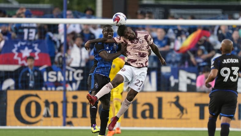 Jun 17, 2023; San Jose, California, USA; Portland Timbers forward Dairon Asprilla (27) and San Jose Earthquakes defender Jonathan Mensah (left) leap for the ball during the first half at PayPal Park. Mandatory Credit: Darren Yamashita-USA TODAY Sports