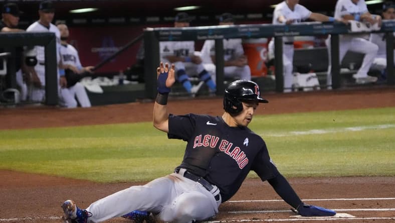 Jun 18, 2023; Phoenix, Arizona, USA; Cleveland Guardians left fielder Steven Kwan (38) slides and scores a run against the Arizona Diamondbacks during the first inning at Chase Field. Mandatory Credit: Joe Camporeale-USA TODAY Sports