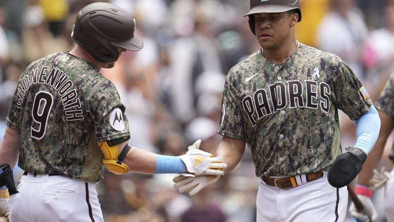 Jun 18, 2023; San Diego, California, USA; San Diego Padres left fielder Juan Soto (right) is congratulated by first baseman Jake Cronenworth (9) after scoring against the Tampa Bay Rays during the third inning at Petco Park. Mandatory Credit: Ray Acevedo-USA TODAY Sports
