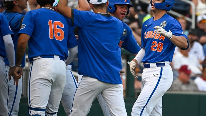 Jun 18, 2023; Omaha, NE, USA; Florida Gators designated hitter Luke Heyman (28) greets teammates after hitting a home run against the Oral Roberts Golden Eagles in the fourth inning at Charles Schwab Field Omaha. Mandatory Credit: Steven Branscombe-USA TODAY Sports