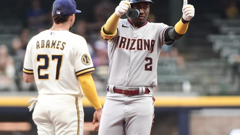 Jun 19, 2023; Milwaukee, Wisconsin, USA; Arizona Diamondbacks shortstop Geraldo Perdomo (2) reacts after hitting a double in the first inning as Milwaukee Brewers shortstop Willy Adames (27) looks on at American Family Field. Mandatory Credit: Benny Sieu-USA TODAY Sports