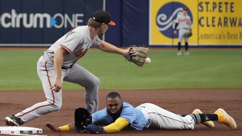 Jun 21, 2023; St. Petersburg, Florida, USA; Tampa Bay Rays center fielder Manuel Margot (13) dives safely into third as Baltimore Orioles third baseman Gunnar Henderson (2) tries to make the tag off a sacrifice fly hit by catcher Christian Bethancourt (not pictured) during the second inning at Tropicana Field. Mandatory Credit: Dave Nelson-USA TODAY Sports
