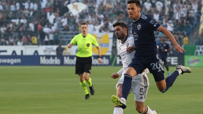 Jun 21, 2023; Carson, California, USA; Sporting Kansas City forward Daniel Salloi (20) fights for the ball against LA Galaxy midfielder Gaston Brugman (5) during the first half of the MLS game at Dignity Health Sports Park. Mandatory Credit: Kiyoshi Mio-USA TODAY Sports