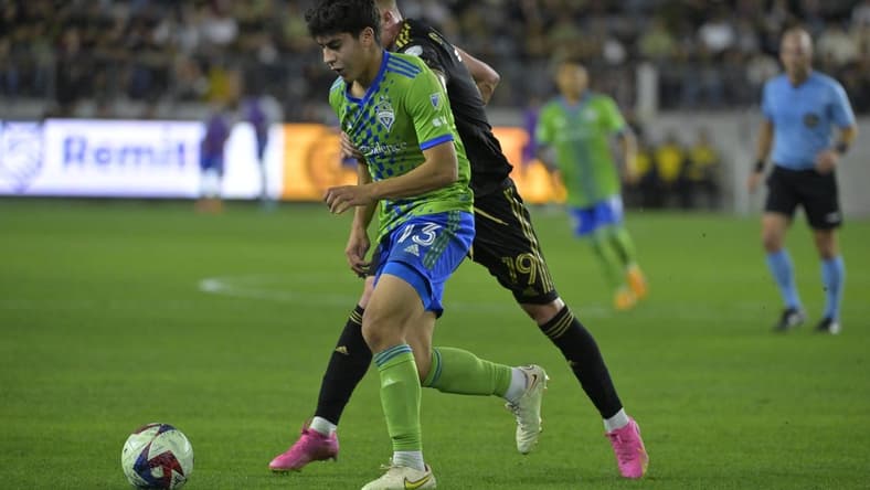 Jun 21, 2023; Los Angeles, California, USA; Seattle Sounders midfielder Obed Vargas (73) runs with the ball against Los Angeles FC player Mateusz Bogusz (19) during the game at BMO Stadium. Mandatory Credit: Jayne Kamin-Oncea-USA TODAY Sports