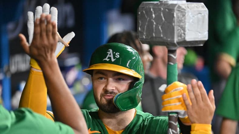 Jun 23, 2023; Toronto, Ontario, CAN; Oakland Athletics catcher Shea Langeliers (23) celebrates in the dugout with the team home run hammer after hitting a solo home run against the Toronto Blue Jays in the ninth inning at Rogers Centre. Mandatory Credit: Dan Hamilton-USA TODAY Sports
