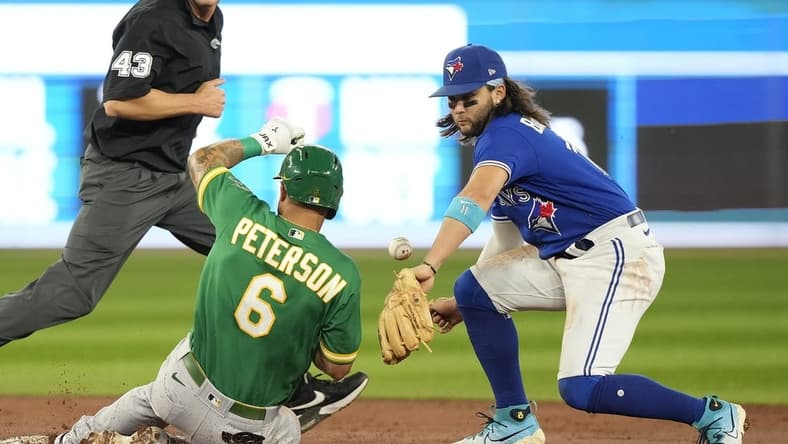 Jun 24, 2023; Toronto, Ontario, CAN; Oakland Athletics third baseman Jace Peterson (6) slides safely into second base on a double as Toronto Blue Jays shortstop Bo Bichette (11) misses the catch in during the second inning at Rogers Centre. Mandatory Credit: John E. Sokolowski-USA TODAY Sports