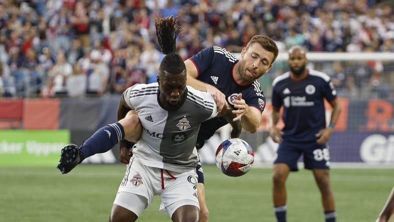 Jun 24, 2023; Foxborough, Massachusetts, USA; Toronto FC forward C.J. Sapong (9) tries to hold off New England Revolution defender Dave Romney (2) during the first half at Gillette Stadium. Mandatory Credit: Winslow Townson-USA TODAY Sports