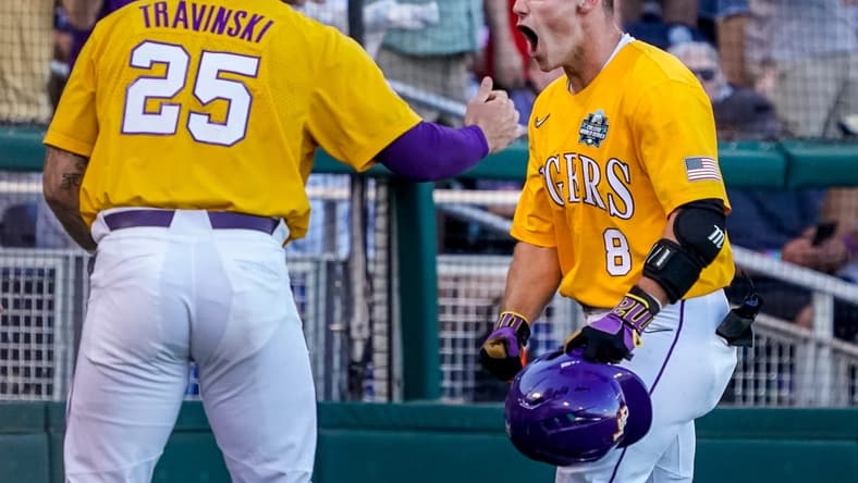 Jun 24, 2023; Omaha, NE, USA; LSU Tigers second baseman Gavin Dugas (8) celebrates with catcher Hayden Travinski (25) after scoring a home run against the Florida Gators during the third inning at Charles Schwab Field Omaha. Mandatory Credit: Dylan Widger-USA TODAY Sports