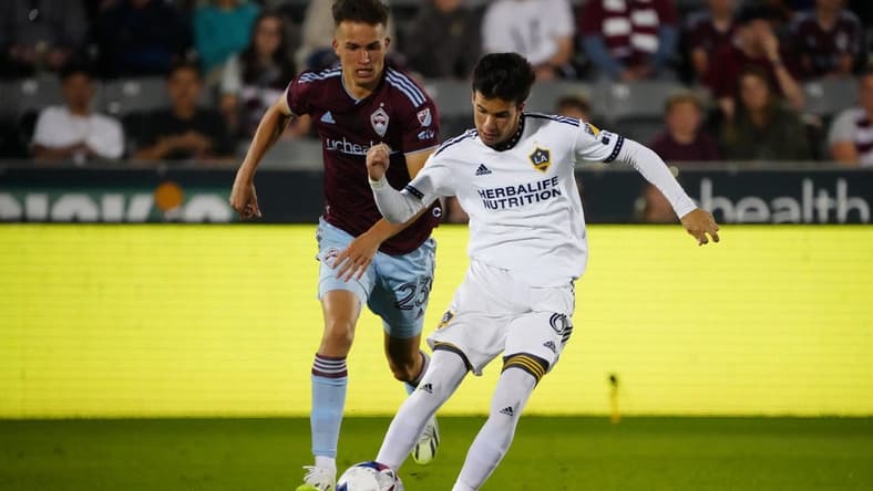 Jun 24, 2023; Commerce City, Colorado, USA; Los Angeles Galaxy midfielder Riqui Puig (6) controls the ball against Colorado Rapids midfielder Cole Bassett (23) during the second half at Dick's Sporting Goods Park. Mandatory Credit: Ron Chenoy-USA TODAY Sports