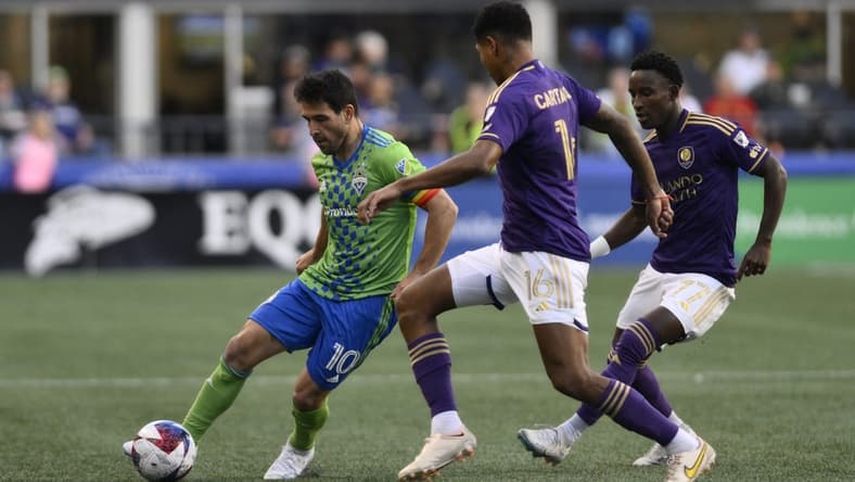 Jun 24, 2023; Seattle, Washington, USA; Seattle Sounders midfielder Nicolas Lodeiro (10) dribbles the ball against Orlando City midfielder Wilder Cartagena (16) during the first half at Lumen Field. Mandatory Credit: Steven Bisig-USA TODAY Sports