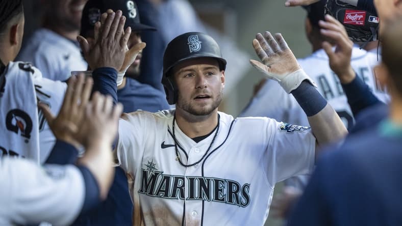 Jun 26, 2023; Seattle, Washington, USA; Seattle Mariners left fielder Jarred Kelenic (10) is congratulated by teammates in the dugout after scoring a run against the Washington Nationals during the fifth inning at T-Mobile Park. Mandatory Credit: Stephen Brashear-USA TODAY Sports