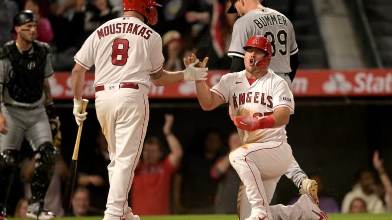 Jun 26, 2023; Anaheim, California, USA; Los Angeles Angels center fielder Mike Trout (27) celebrates with first baseman Mike Moustakas (8) after scoring from third on a wild pitch by Chicago White Sox relief pitcher Aaron Bummer (39) to win the game in the ninth inning at Angel Stadium. Mandatory Credit: Jayne Kamin-Oncea-USA TODAY Sports