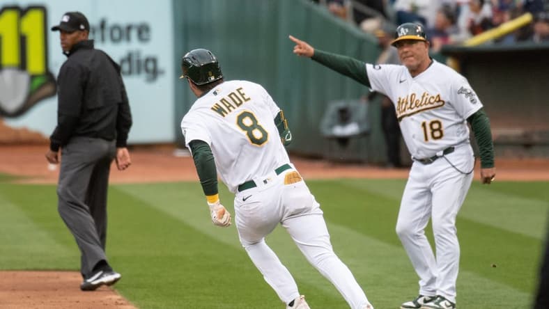 Jun 27, 2023; Oakland, California, USA; Oakland Athletics first base coach Mike Aldrete (18) directs left fielder Tyler Wade (8) to advance to second base during the third inning against the New York Yankees at Oakland-Alameda County Coliseum. Mandatory Credit: Ed Szczepanski-USA TODAY Sports
