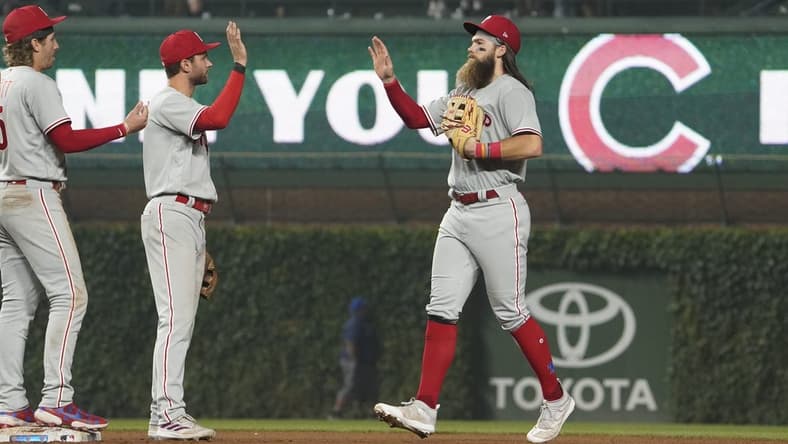 Jun 27, 2023; Chicago, Illinois, USA; Philadelphia Phillies center fielder Brandon Marsh (right) and shortstop Trea Turner (center) react after defeating the Chicago Cubs at Wrigley Field. Mandatory Credit: David Banks-USA TODAY Sports
