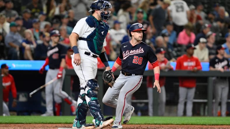 Jun 27, 2023; Seattle, Washington, USA; Washington Nationals right fielder Lane Thomas (28) scores a run off a single hit by second baseman Luis Garcia (not pictured) during the eleventh inning at T-Mobile Park. Mandatory Credit: Steven Bisig-USA TODAY Sports