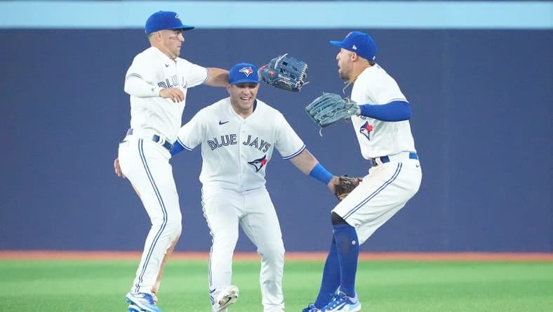 Jun 28, 2023; Toronto, Ontario, CAN; Toronto Blue Jays right fielder George Springer (4) and Toronto Blue Jays center fielder Daulton Varsho (25) and Toronto Blue Jays left fielder Whit Merrifield (15) celebrate the win against the San Francisco Giants at the end of the ninth inning at Rogers Centre. Mandatory Credit: Nick Turchiaro-USA TODAY Sports
