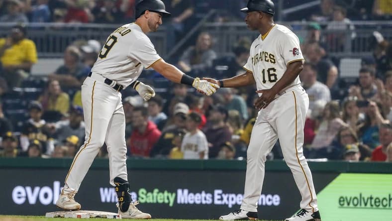 Jun 28, 2023; Pittsburgh, Pennsylvania, USA; Pittsburgh Pirates third baseman Jared Triolo (19) celebrates his first major league hit with first base coach Tarrik Brock (16) against the San Diego Padres during the eighth inning at PNC Park. Pittsburgh won 7-1. Mandatory Credit: Charles LeClaire-USA TODAY Sports