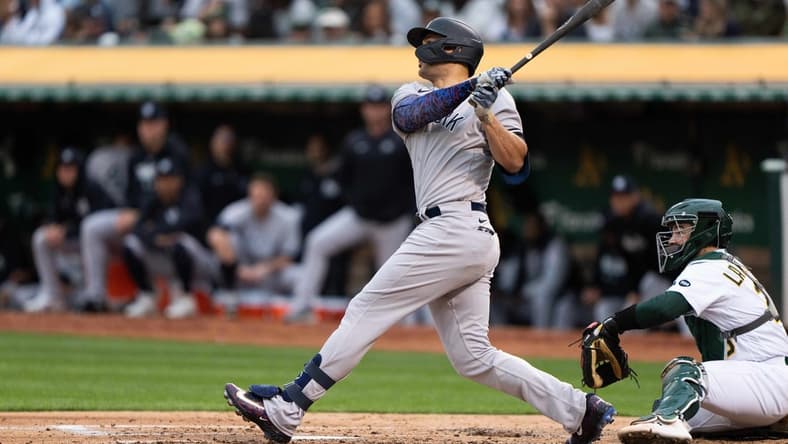 Jun 28, 2023; Oakland, California, USA; New York Yankees designated hitter Giancarlo Stanton (27) hits a solo home run during the fourth inning against the Oakland Athletics at Oakland-Alameda County Coliseum. Mandatory Credit: Stan Szeto-USA TODAY Sports