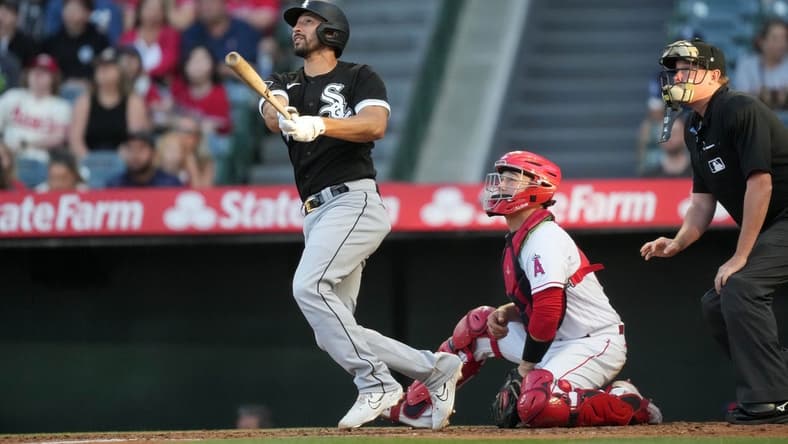 Jun 28, 2023; Anaheim, California, USA; Chicago White Sox catcher Seby Zavala (44) follows through on a home run in the second inning as Los Angeles Angels catcher Chad Wallach (35) and home plate umpire Chad Whiston watch at Angel Stadium. Mandatory Credit: Kirby Lee-USA TODAY Sports