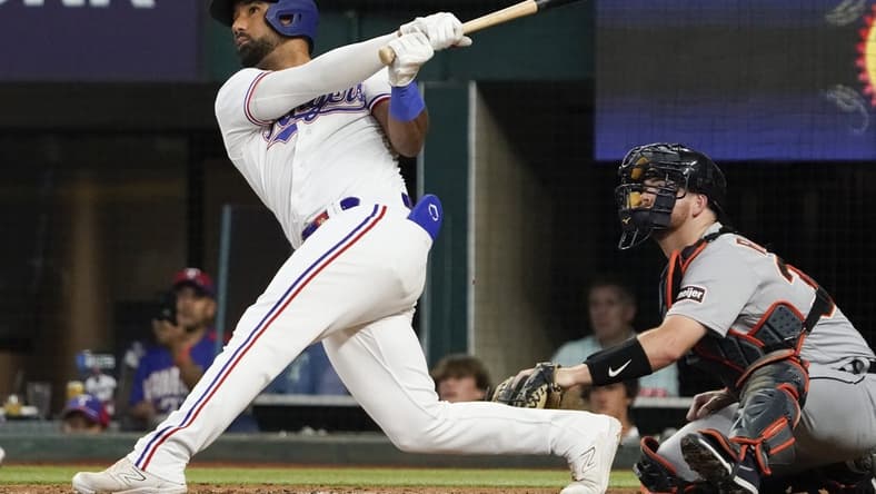 Jun 29, 2023; Arlington, Texas, USA; Texas Rangers shortstop Ezequiel Duran (20) follows thru on a solo home run during the fourth inning against the Detroit Tigers at Globe Life Field. Mandatory Credit: Raymond Carlin III-USA TODAY Sports
