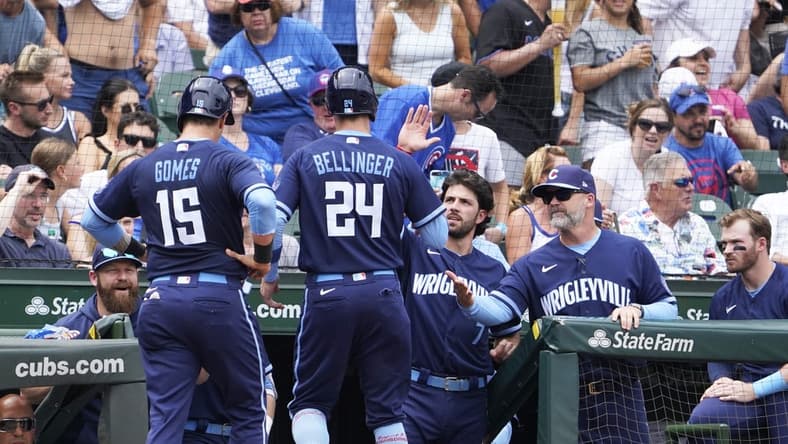Jun 30, 2023; Chicago, Illinois, USA; Chicago Cubs center fielder Cody Bellinger (24) and catcher Yan Gomes (15) are greeted after scoring against the Cleveland Guardians during the fourth inning at Wrigley Field. Mandatory Credit: David Banks-USA TODAY Sports