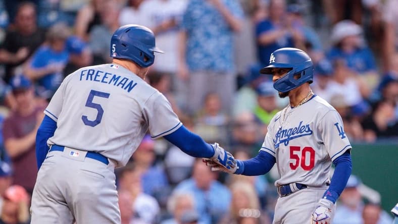 Jun 30, 2023; Kansas City, Missouri, USA;  Los Angeles Dodgers right fielder Mookie Betts (50) slaps hands with Los Angeles Dodgers first baseman Freddie Freeman (5) after scoring during the third inning against the Kansas City Royals at Kauffman Stadium. Mandatory Credit: William Purnell-USA TODAY Sports