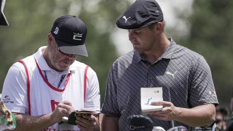 May 6, 2021; Charlotte, North Carolina, USA; Bryson DeChambeau talks with his caddie Tim Tucker during the first round of the Wells Fargo Championship golf tournament. Mandatory Credit: Jim Dedmon-USA TODAY Sports