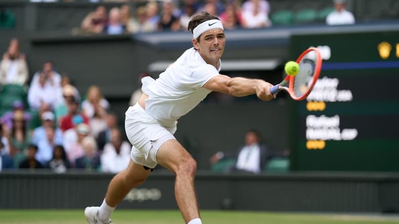 Jul 6, 2022; London, England, United Kingdom;
Taylor Fritz (USA) returns a shot during his quarter finals men s singles match against Rafael Nadal (ESP) on Centre court at All England Lawn Tennis and Croquet Club. Mandatory Credit: Peter van den Berg-USA TODAY Sports