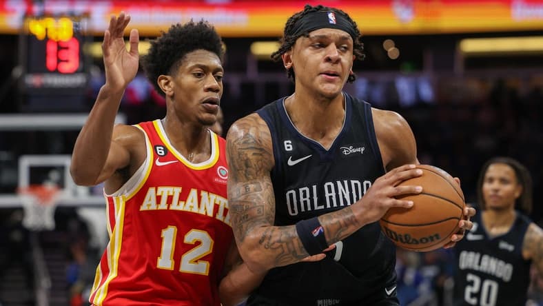 Dec 14, 2022; Orlando, Florida, USA; Atlanta Hawks forward De'Andre Hunter (12) guards Orlando Magic forward Paolo Banchero (5) in the fourth quarter at Amway Center. Mandatory Credit: Nathan Ray Seebeck-USA TODAY Sports