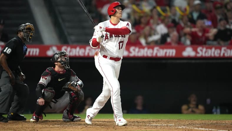 Jun 30, 2023; Anaheim, California, USA; Los Angeles Angels starting pitcher Shohei Ohtani (17) follows through on a solo home run in the sixth inning as Arizona Diamondbacks catcher Carson Kelly (18) and home plate umpire Ramon De Jesus watch at Angel Stadium. Mandatory Credit: Kirby Lee-USA TODAY Sports
