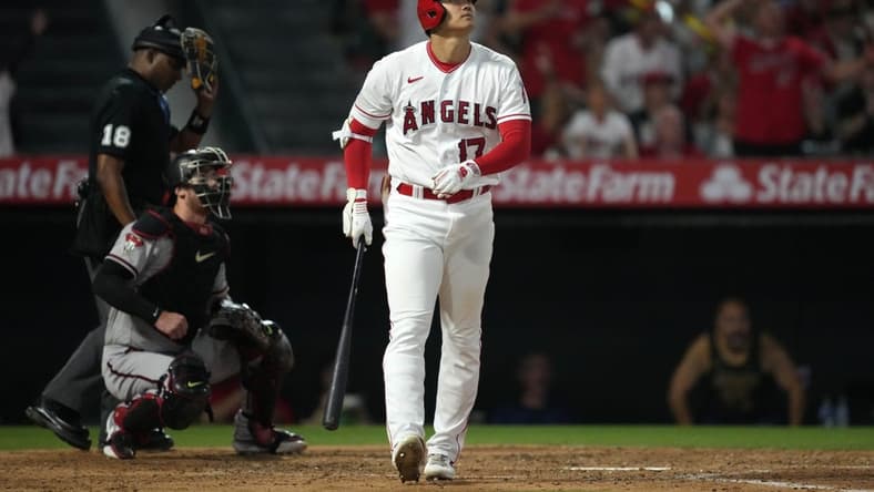 Jun 30, 2023; Anaheim, California, USA; Los Angeles Angels star Shohei Ohtani (17) follows through on a solo home run in the sixth inning as Arizona Diamondbacks catcher Carson Kelly (18) and home plate umpire Ramon De Jesus watch at Angel Stadium. Mandatory Credit: Kirby Lee-USA TODAY Sports