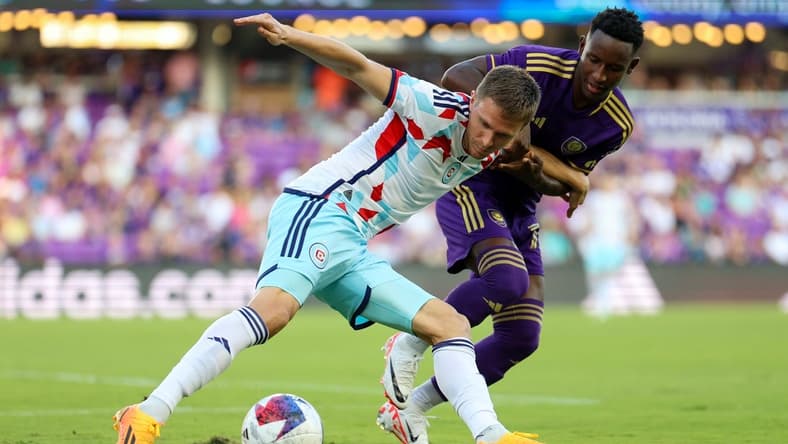 Jul 1, 2023; Orlando, Florida, USA; Chicago Fire FC defender Arnaud Souquet (2) and Orlando City SC forward Ivan Angulo (77) battle for the ball in the first half at Exploria Stadium. Mandatory Credit: Nathan Ray Seebeck-USA TODAY Sports