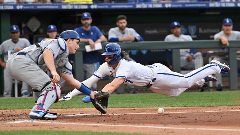 Jul 1, 2023; Kansas City, Missouri, USA;  Kansas City Royals shortstop Bobby Witt Jr. (7) dives home to score a run against Los Angeles Dodgers catcher Will Smith (16) in the first inning at Kauffman Stadium. Mandatory Credit: Peter Aiken-USA TODAY Sports