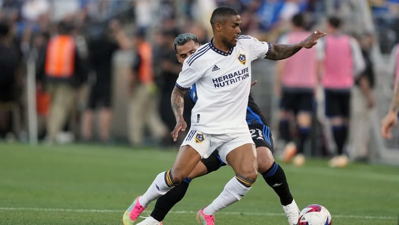 Jul 1, 2023; Stanford, California, USA; Los Angeles Galaxy forward Douglas Costa (10) dribbles against San Jose Earthquakes defender Miguel Trauco (obscured) during the first half at Stanford Stadium. Mandatory Credit: Darren Yamashita-USA TODAY Sports