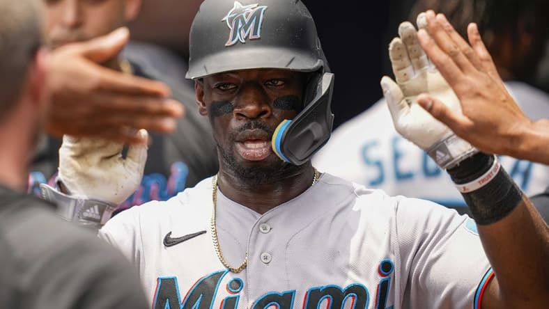 Jul 2, 2023; Cumberland, Georgia, USA; Miami Marlins center fielder Jonathan Davis (49) gets high fives after scoring a run against the Atlanta Braves during the second inning at Truist Park. Mandatory Credit: Dale Zanine-USA TODAY Sports