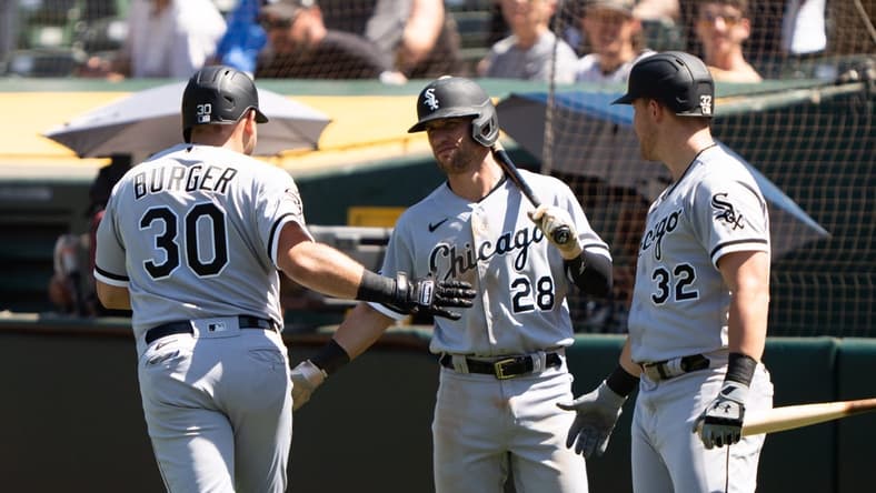 Jul 2, 2023; Oakland, California, USA; Chicago White Sox third baseman Jake Burger (30) celebrates with shortstop Zach Remillard (28) and right fielder Gavin Sheets (32) after hitting a solo home run during the seventh inning against the Oakland Athletics at Oakland-Alameda County Coliseum. Mandatory Credit: Stan Szeto-USA TODAY Sports
